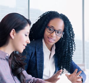 Black female business leader talking with employee serious small