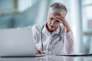 Female Physician Stress Looking at Laptop