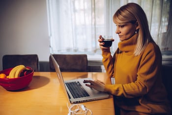 Female Middle Aged Remote Employee Drinking Wine on Job_Small