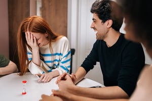 Friends playing games together laughing at a table