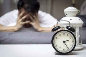 Asian man in bed suffering insomnia and sleep disorder thinking about his problem at night