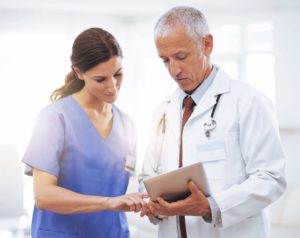 Shot of patient care team looking at a digital tablet.