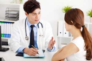 Doctor speaking with young female patient in office