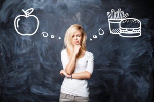 Woman makes a choice between bad food and healthy eating