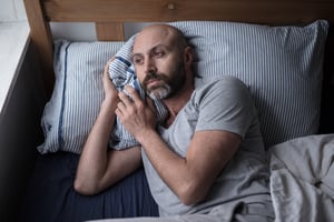 Man with depression laying in bed_mental health