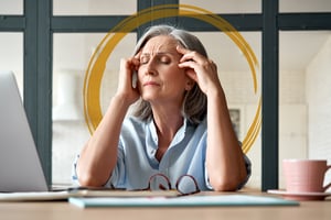 Older Woman Visbily Stressed in front of computer