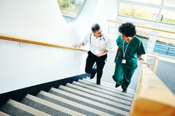 Two physicians walking on stairs_mentor & mentoree