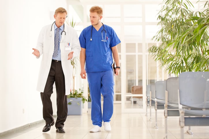 two-male-physicians-walking-down-hallway